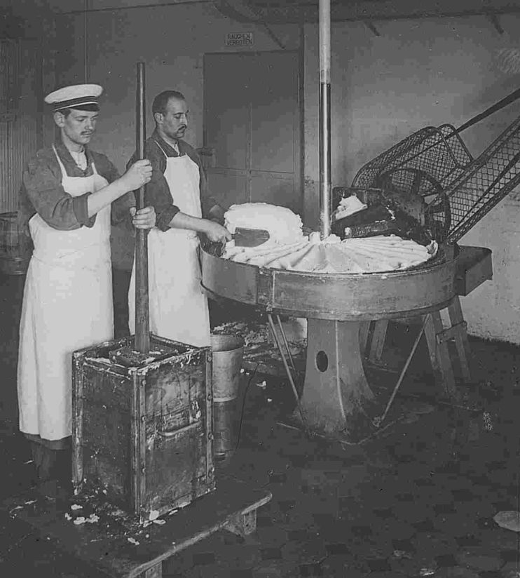 Arbeiter an der Butterknetmaschine in der Meierei C. Bolle, Berlin, um 1900.