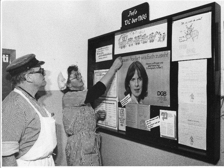 Infobrett der Vertrauensleute der NGG in der Fleischwarenfabrik Oldenburg. Kollegin Annegret Rabethge und Betriebsratsvorsitzender Heinz Mävers, um 1980.